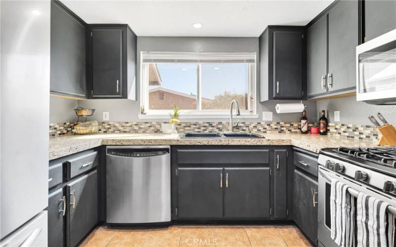 Updated kitchen with granite counters, and glass backsplash.