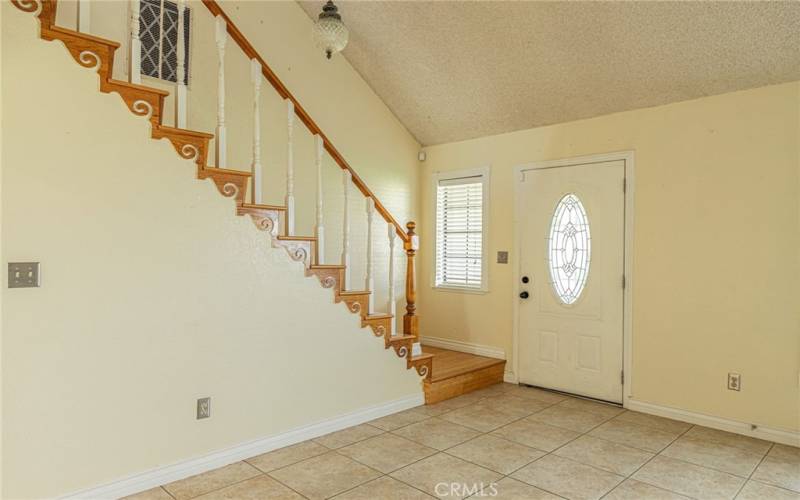 Living room view of the stairs and the front door