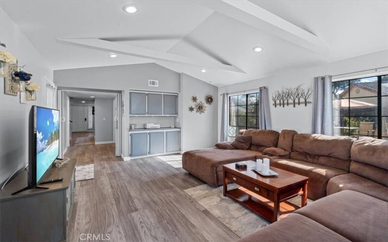 Light-filled living space with vaulted ceilings and built in storage.