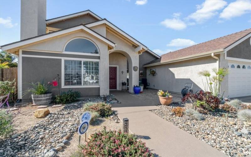 Beautiful, low-maintenance front landscaping dry creek bed, solar lights and granite grip top-coating on the pathways.