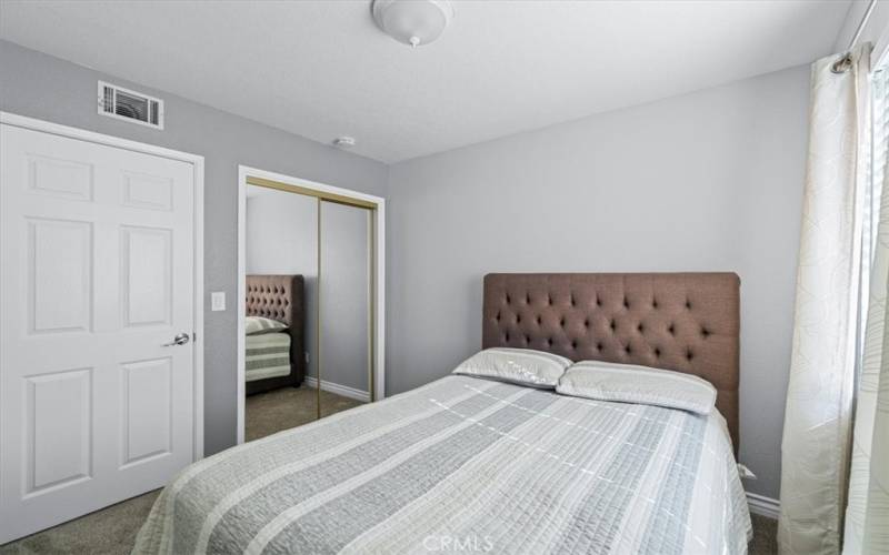 Second bedroom with mirrored closet door.