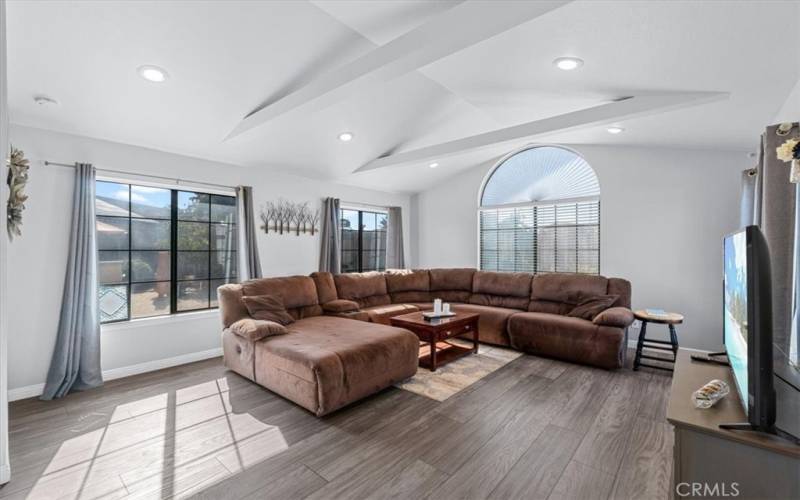 Light-filled room with cathedral ceilings and a patio door to the backyard.