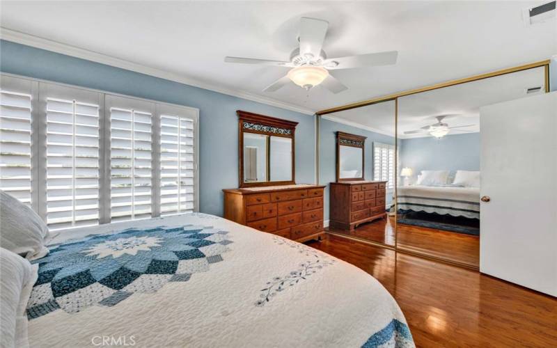 Master bedroom with plantation shutters and mirrored closet