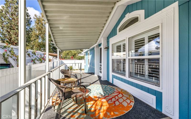 Look at this cottage style porch right out of a magazine with great windows, ideal white vinyl fencing and cool shade.