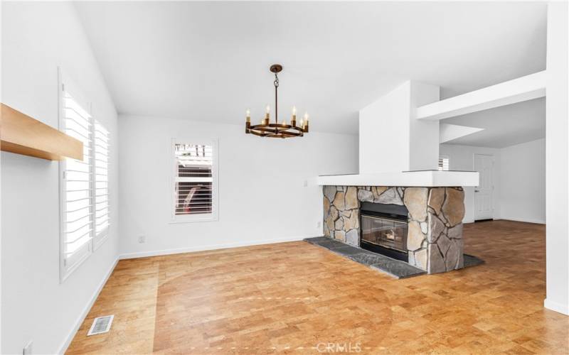 The large living room and formal dining room are divided by a stunning two-sided rock fireplace.