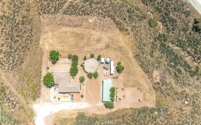 The land that appears to be graded behind the house and round pen is where the land is and it goes down to the street on the upper right side of the picture