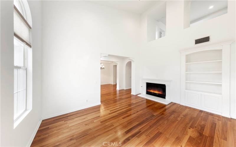 Living room with lots of natural light, high ceiling and fireplace