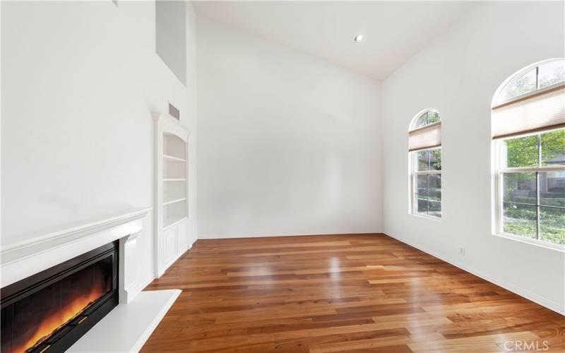 Living room with lots of natural light, high ceiling and fireplace