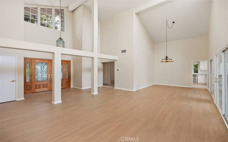 Expansive living room with vaulted ceilings, luxury vinyl plank flooring just added.   Dining area is towards the rear of the photo.