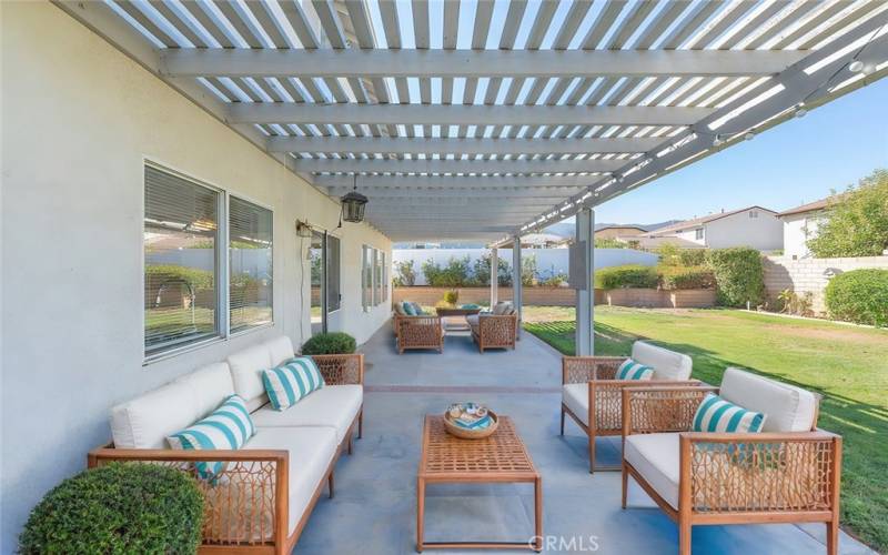 Expansive backyard with a covered patio, perfect for entertaining and ample space for play and outdoor activities.