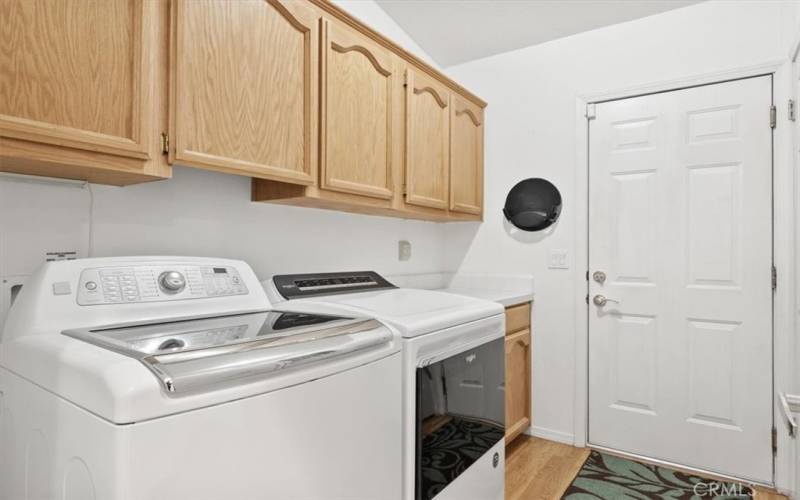 Inside laundry room with storage cabinets, counter space, access to garage and washer plus dryer that are included.