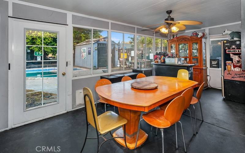 The open and bright sunroom with lighted ceiling fan and a French door that leads to the backyard offers a multitude of designing opportunities.