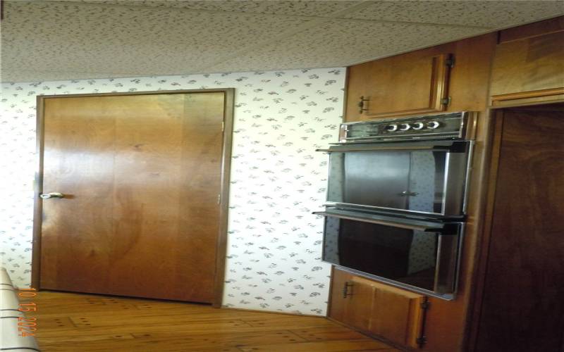 Kitchen has double ovens and the door is to a walk-in pantry.