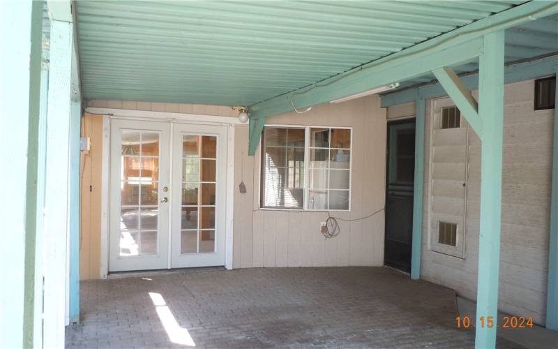 Standing under the patio, looking towards the enclosed patio.  There are 2 sets of double doors, on here, and one leading to the back yard.