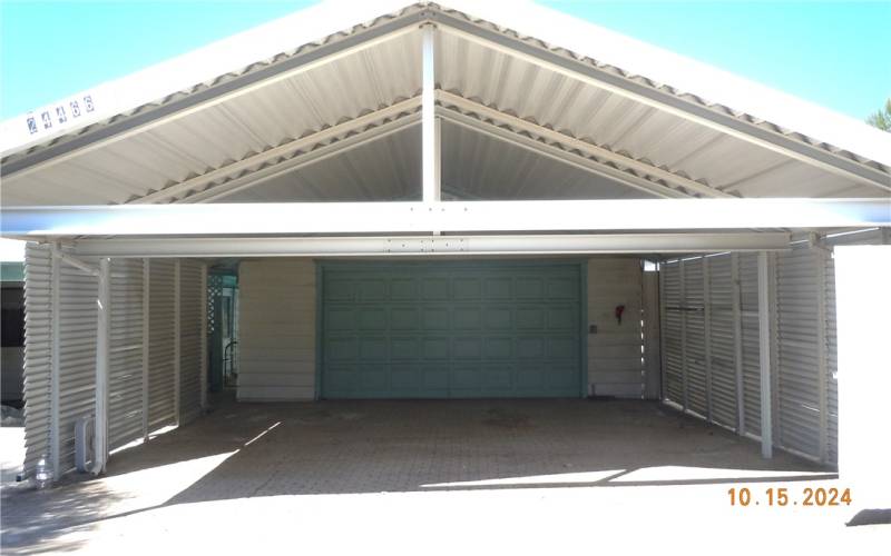 Another view of covered carport, and the garage door just past the carport.