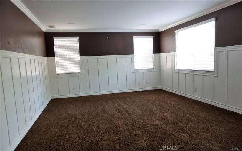 Main bedroom with crown molding , lots of windows and wainscotting