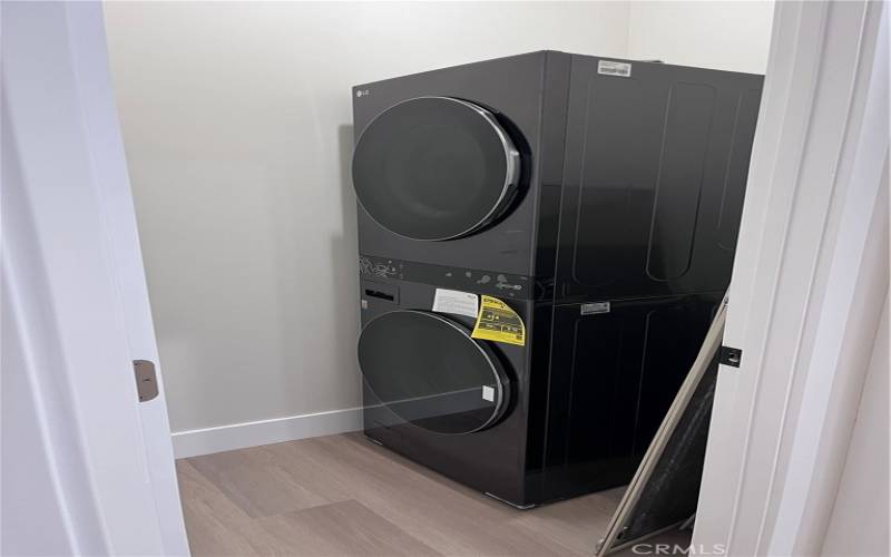 newly installed, sleek black LG washer and dryer set is a part of the all-new appliance package in this modern home. Stacked to optimize space, these high-efficiency machines complement the home's minimalist aesthetic