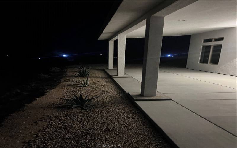 the expansive entryway and wraparound porch provide a serene outdoor space perfect for enjoying the tranquil desert evenings.