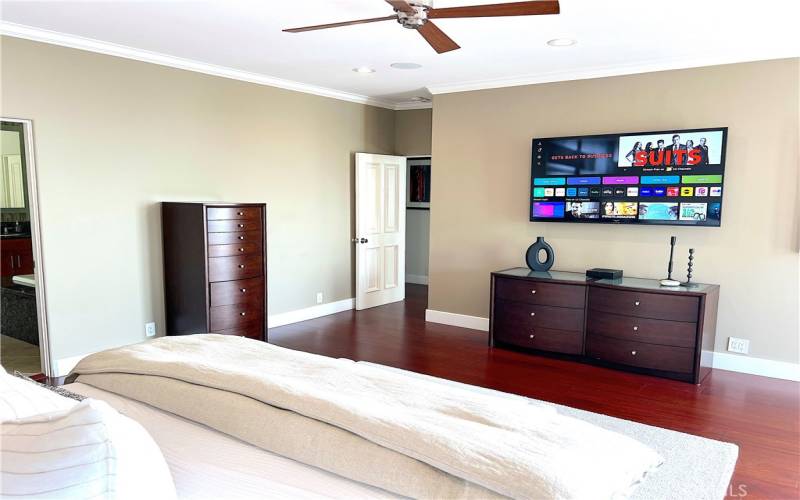 Spacious primary bedroom with smart TV.