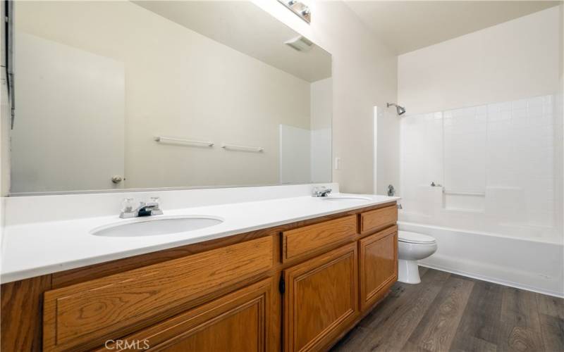 Secondary bathroom with tub and shower and double sink vanity.