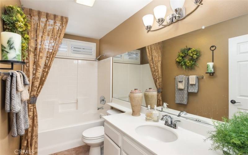 This inviting bathroom combines practical design, a spacious tub-shower combo, and ample vanity space.