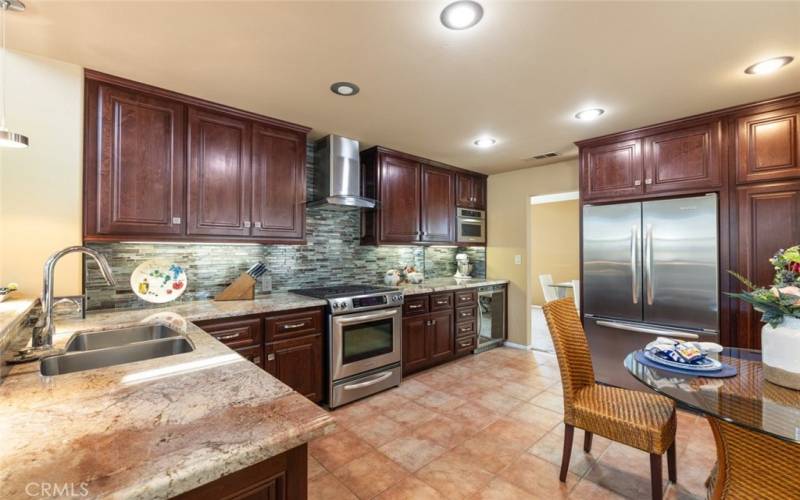 A modern kitchen showcasing sleek stainless steel appliances, elegant granite countertops, and a stylish stone tile backsplash, designed for both function and style.