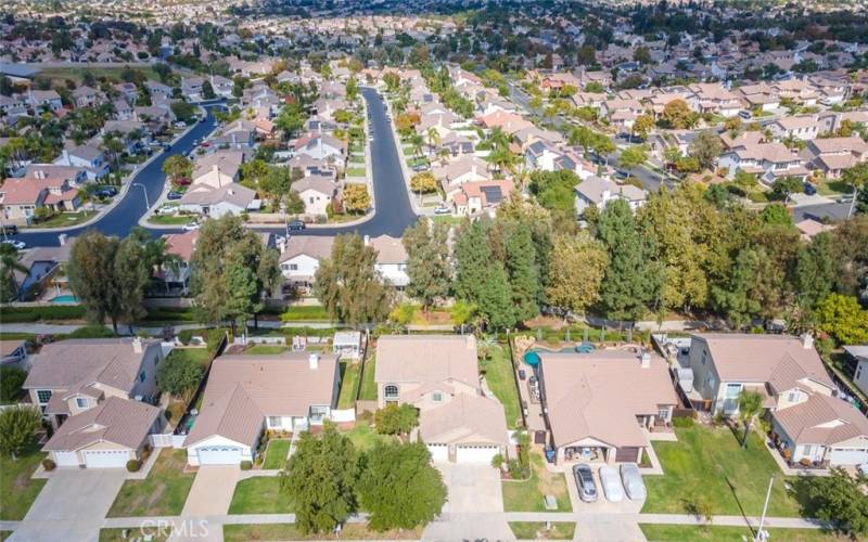 This aerial shot captures the picturesque layout of a suburban neighborhood, featuring well-spaced homes with yards, nestled among curving streets and mature greenery.