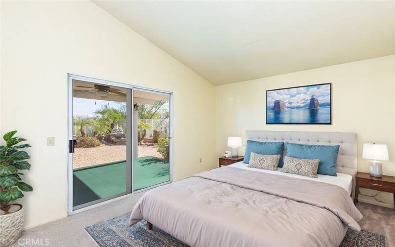 
Spacious primary bedroom with sliding doors leading to a private backyard patio, creating a serene indoor-outdoor retreat.