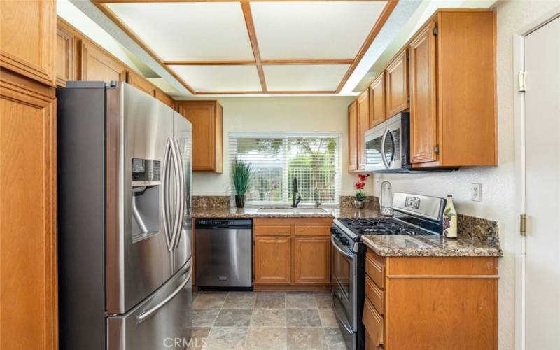 
Modern kitchen featuring sleek stainless steel appliances, granite countertops, and a bright window view, perfect for culinary inspiration.