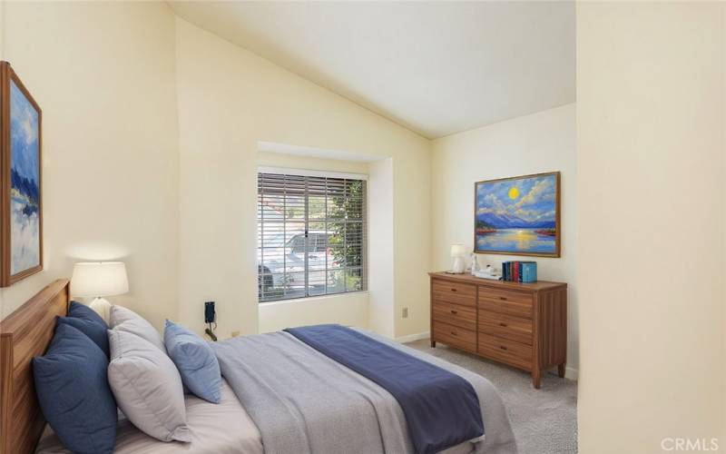 Cozy bedroom with a large window inviting natural light, creating a bright and welcoming atmosphere.