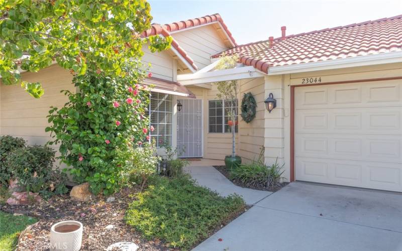 Welcoming entryway trimmed with lush greenery and charming accents, creating a warm first impression.