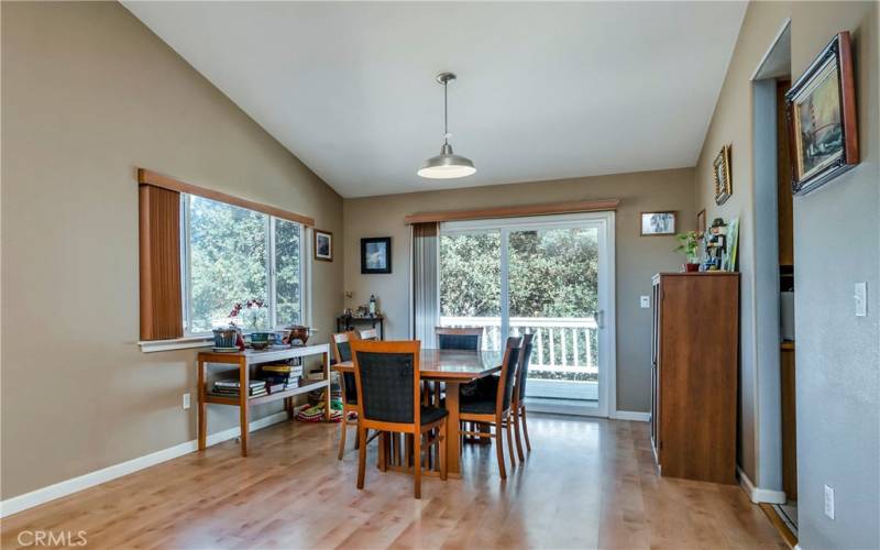 Dining area is open to living area and has sliding glass door to rear deck overlooking garden.