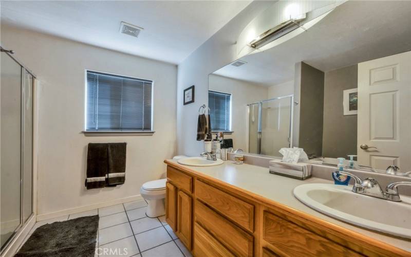 Dual sinks and stand alone shower in primary bathroom.