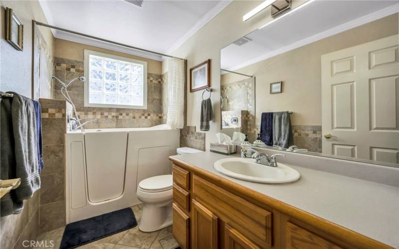 Walk in heated Jacuzzi tub in hall bathroom.