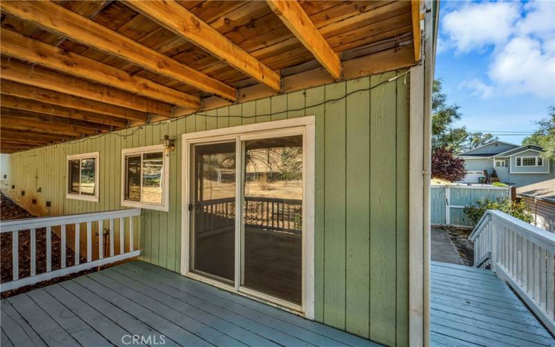 Covered ADU deck with entrance front door off the porch to the right of photo.