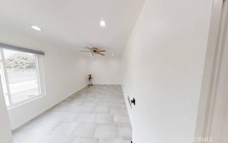 Spacious bedroom, with fan and window to let in fresh air. Door to the living room is on the right.