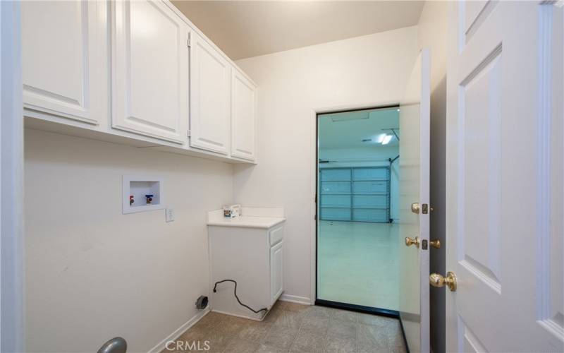 The laundry room has plenty of cabinets and leads to the oversized 2-car garage with painted floor and newer water heater.