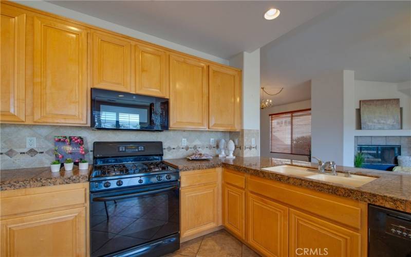 Beautiful kitchen with tile floors, granite counters, custom tiled backsplashes opening to the family room.