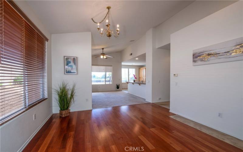 The living/dining room features wood type laminate floors and soaring ceilings.