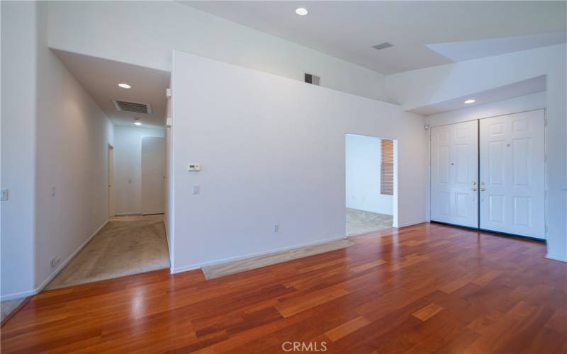 Living room, double door entry, flex room/den/3rd bedroom on right and hall to master and guest bedrooms at left.