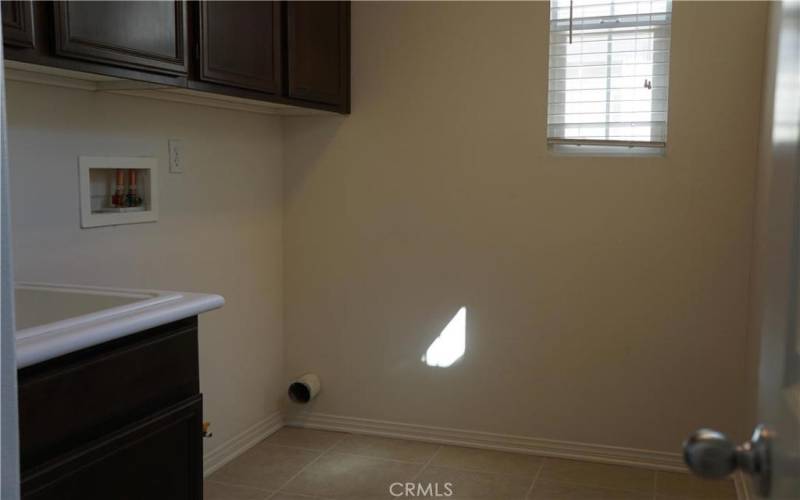 TILE FLOORS IN SPACIOUS LAUNDRY ROOM WITH SINK