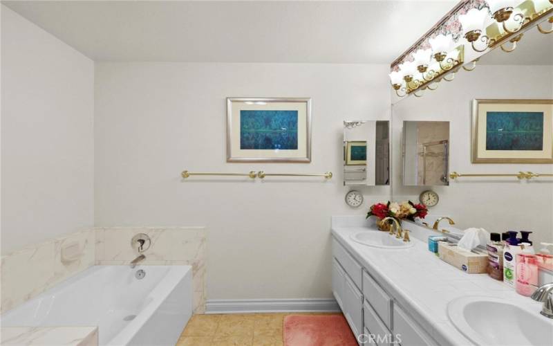 Luxurious primary bath with dual sink vanity, separate bathtub and shower.