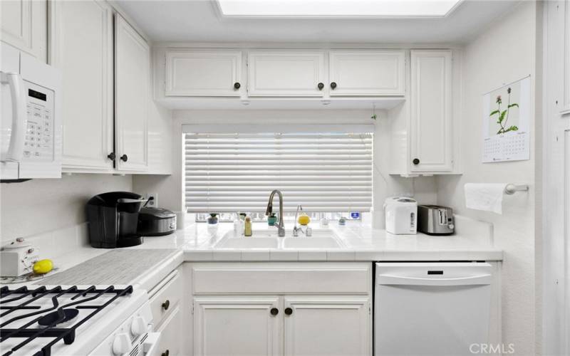 Windows and white cabinetry bring so much light into this space and make it a joyful place to cook while visiting with family and friends. - Open to family room