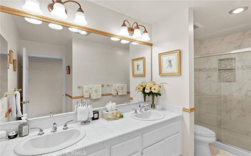 Updated hall bath with dual sink vanity, updated lighting and a gorgeous large shower with insert shelf for soap and shampoo