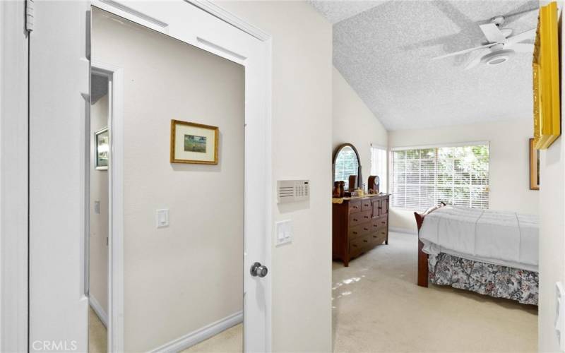 Walking into primary bedroom with mirrored door on walk in closet. Note higher ceilings.  This is a suite and the bath is to your left.