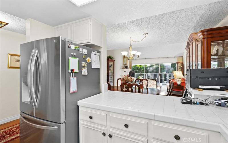 Kitchen facing out with new refrigerator in photo
