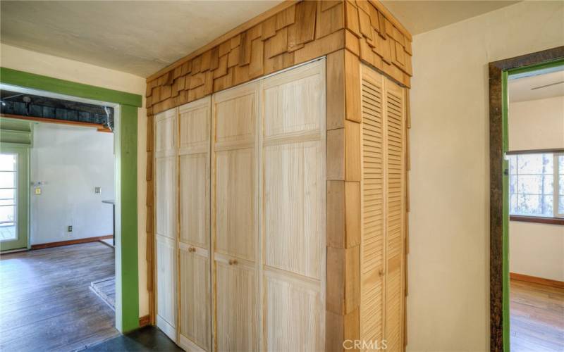 Closet containing hot water heater, small refrigerator, and washer and dryer