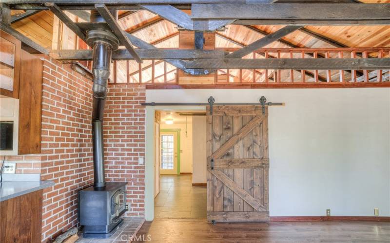 Living Room looking down hallway to front door.  Loft area up above barn door.