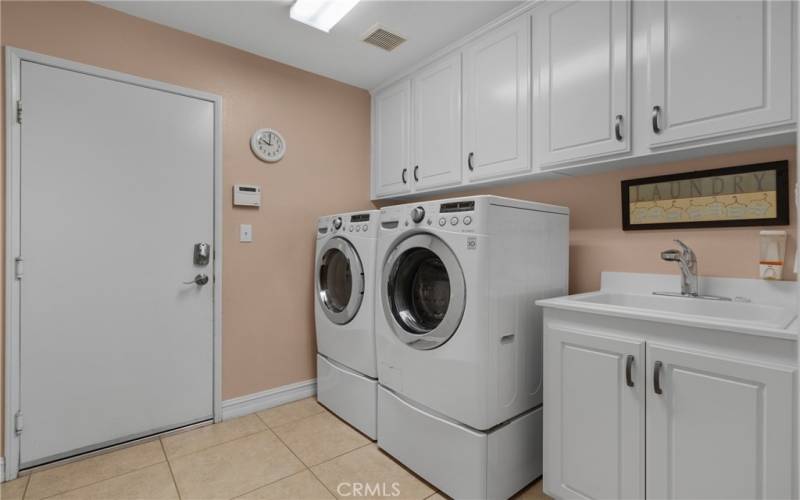 Laundry room with a sink and storage