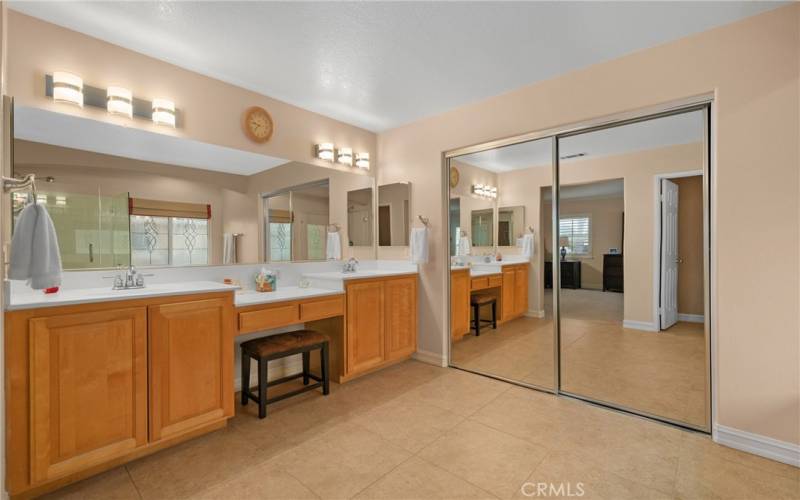 Glam station between double sinks; Walk in closet behind mirrored doors